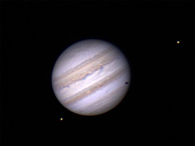 Jupiter with Europa casting a shadow and Io.